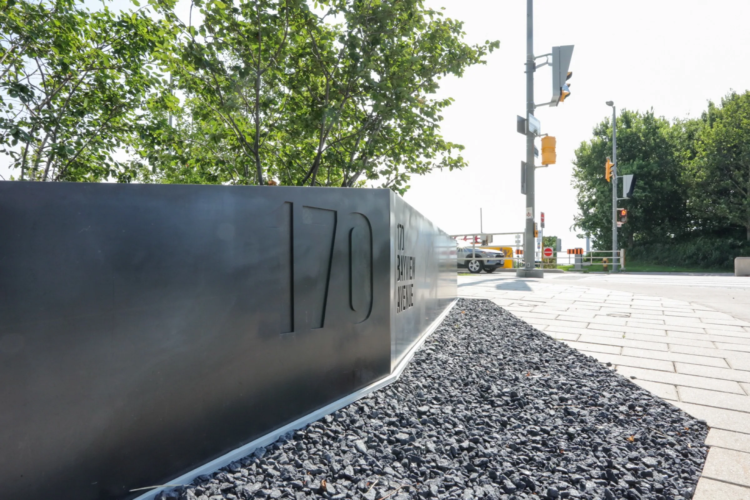 Sculptural metal address feature set into a black stone border
