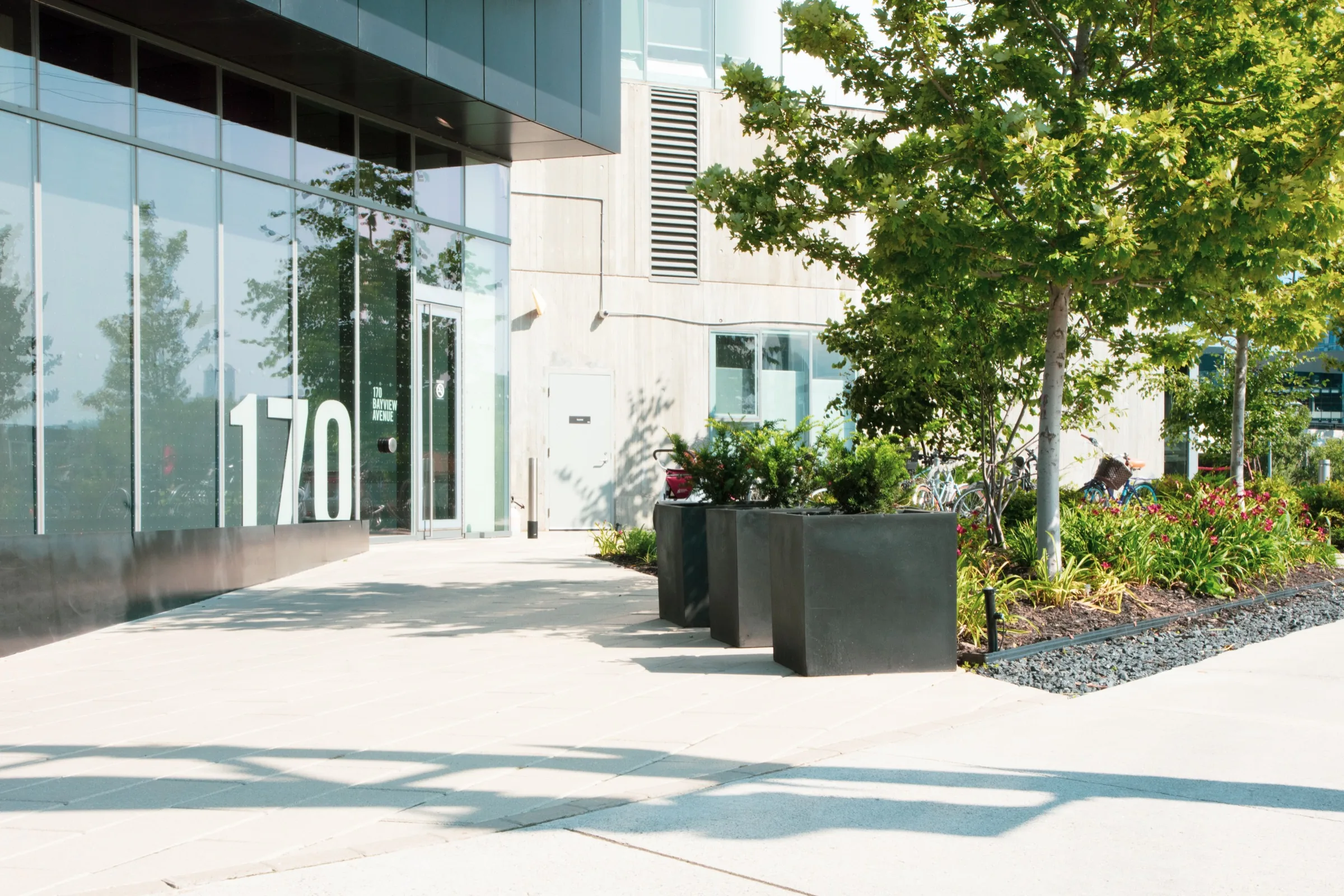 Architectural planters and layered garden beds beside the condominium entrance